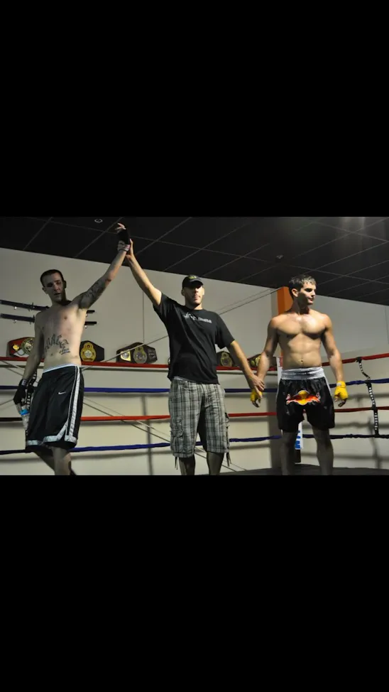 Referee raises opponent's hand after an exhibition kickboxing match